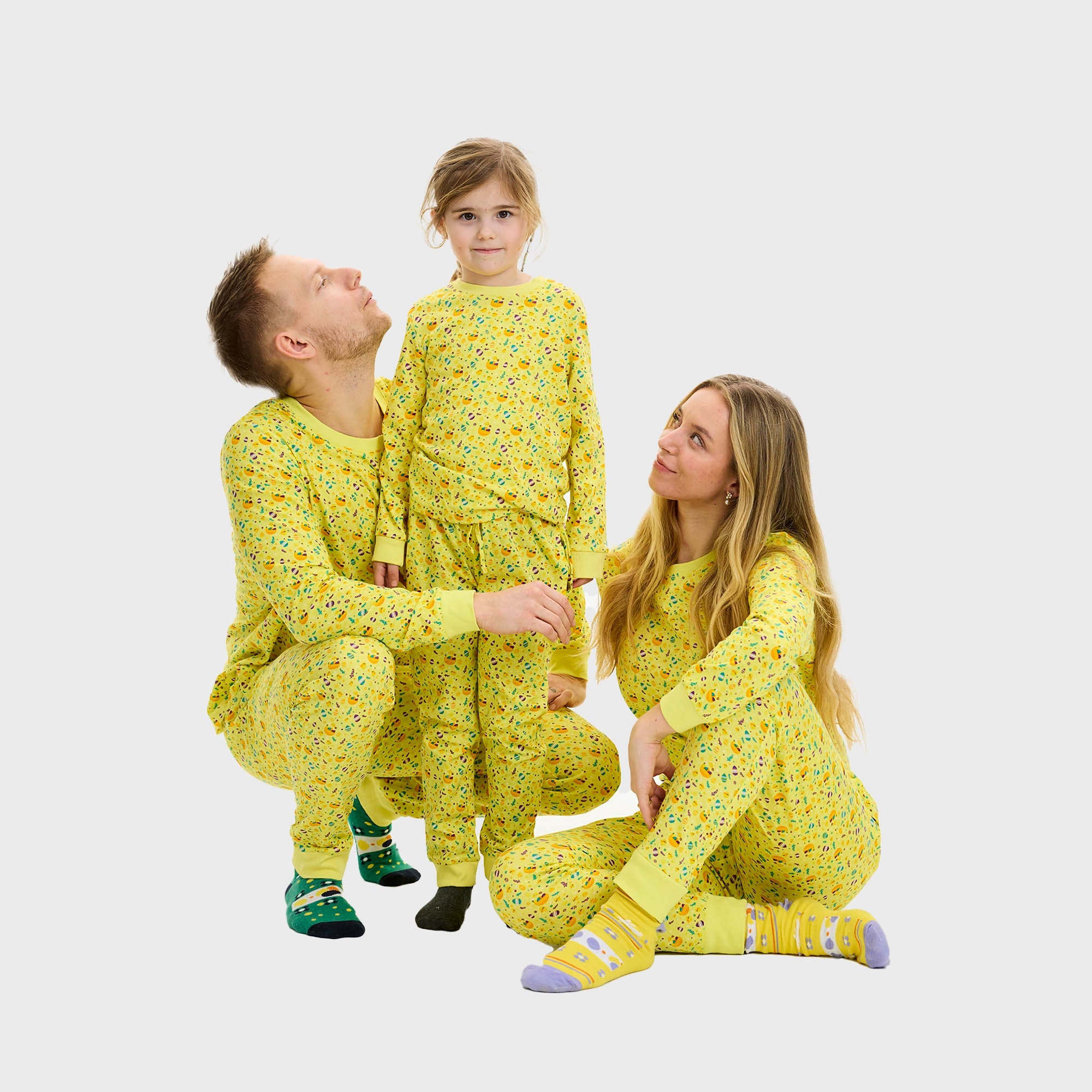 Eine Frau und ein Kind tragen gelbe Osterpyjamas.